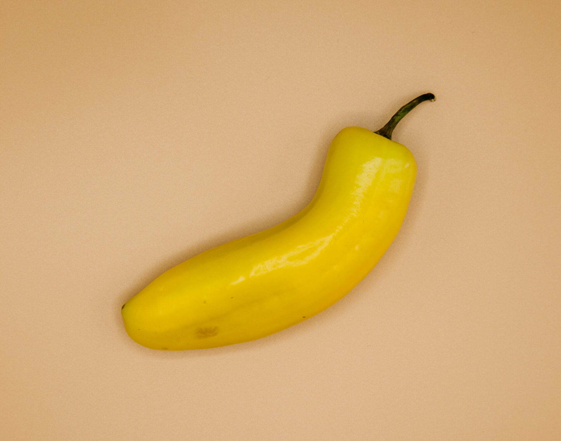 a yellow banana on a white surface