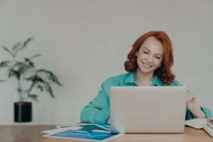 a woman sitting at a desk with a laptop